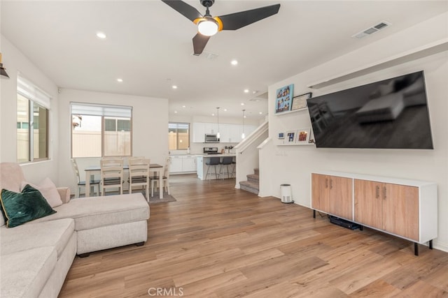 living room featuring ceiling fan and light wood-type flooring