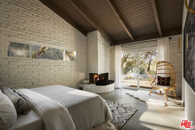 bedroom with an outdoor brick fireplace, access to exterior, concrete flooring, and multiple windows