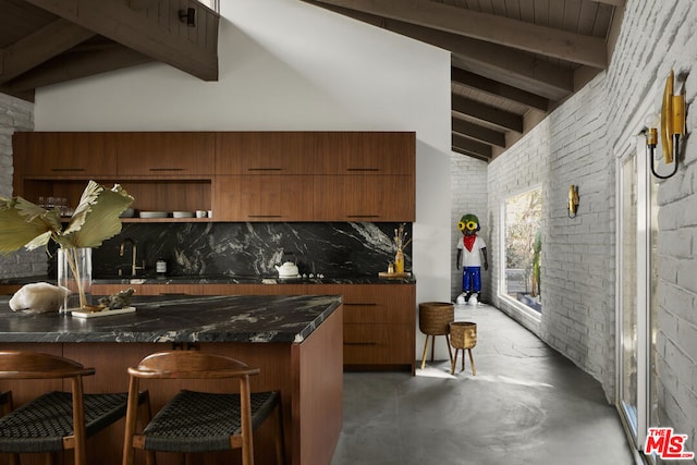 kitchen featuring beam ceiling, a kitchen breakfast bar, brick wall, backsplash, and kitchen peninsula