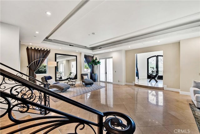 exercise room featuring a raised ceiling and french doors