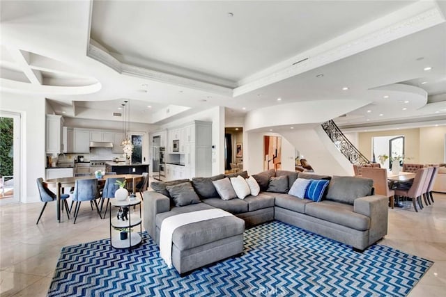 living room with a tray ceiling, a wealth of natural light, and sink