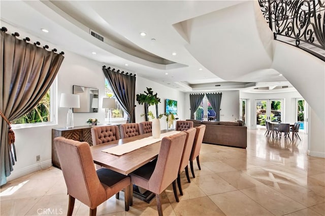 tiled dining room featuring a raised ceiling