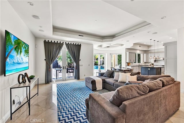 living room with french doors and a raised ceiling