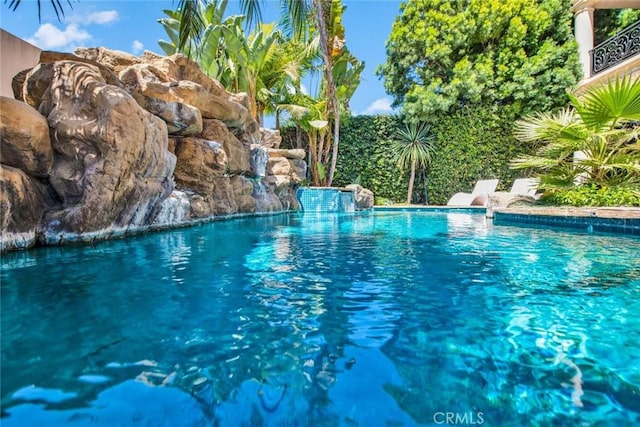 view of swimming pool with pool water feature