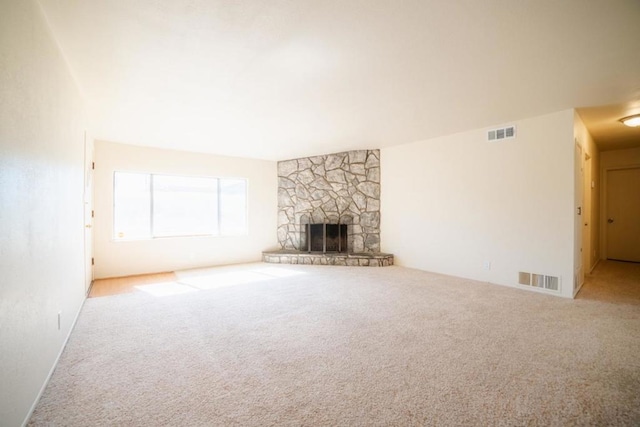 unfurnished living room with light carpet and a stone fireplace