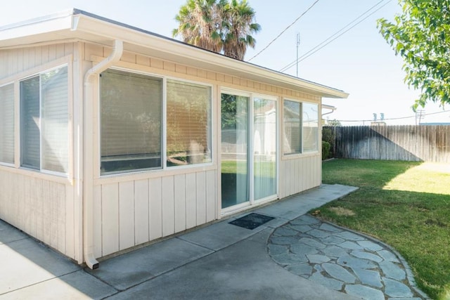 view of side of home with a yard and a patio