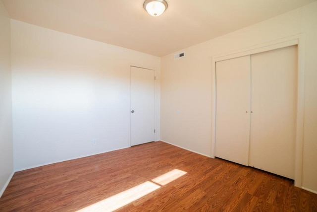 unfurnished bedroom with a closet and dark wood-type flooring