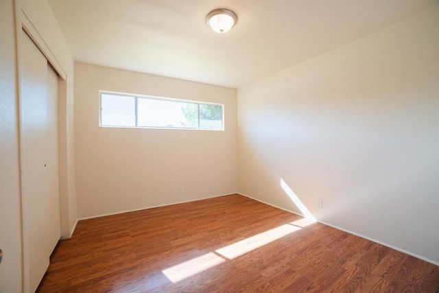 unfurnished bedroom with a closet and wood-type flooring