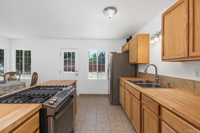 kitchen featuring light tile patterned flooring, stainless steel appliances, sink, and wooden counters