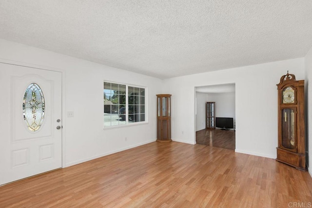 entrance foyer featuring light wood-type flooring and a textured ceiling