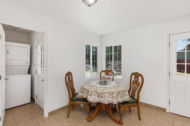 dining room with stacked washer / drying machine and light tile patterned flooring