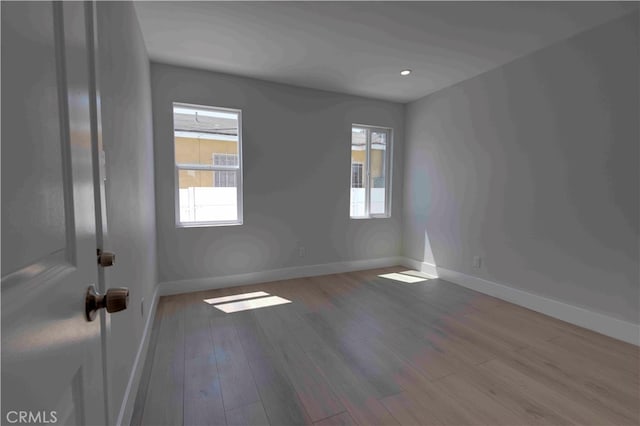 spare room with a healthy amount of sunlight and hardwood / wood-style flooring