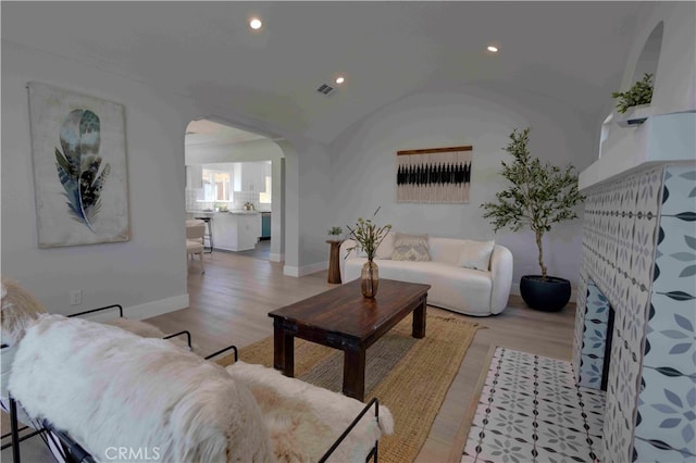 living room with vaulted ceiling and light hardwood / wood-style flooring