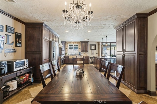 dining room featuring a textured ceiling, crown molding, and a notable chandelier