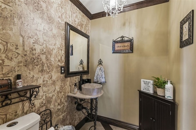 bathroom featuring toilet, crown molding, and a notable chandelier