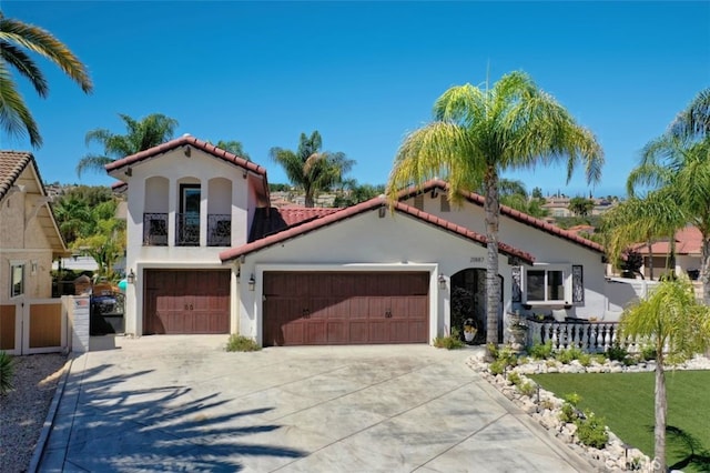 mediterranean / spanish-style house featuring a garage and a balcony