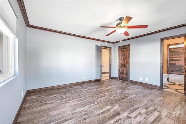 unfurnished bedroom featuring ceiling fan, crown molding, ensuite bathroom, and hardwood / wood-style flooring