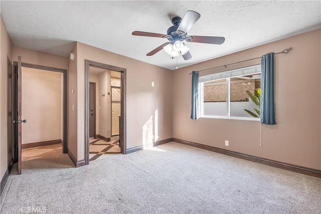 unfurnished bedroom with ceiling fan, light colored carpet, and a textured ceiling