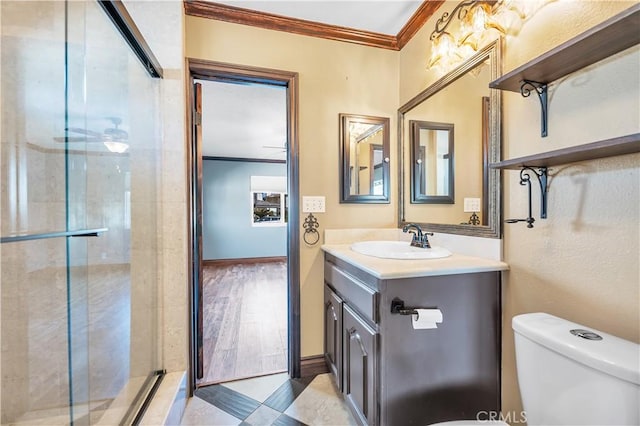 bathroom featuring vanity, toilet, crown molding, and an enclosed shower