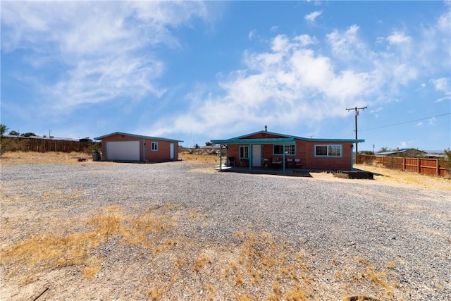rear view of property with fence, an outbuilding, and a garage