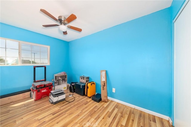 interior space featuring baseboards, a ceiling fan, and wood finished floors