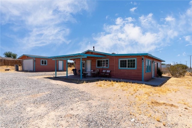 view of front of property with a patio and an outbuilding