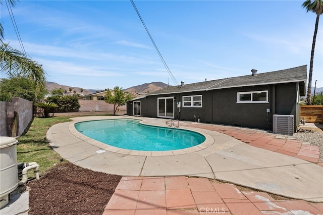 view of swimming pool featuring a mountain view, a patio area, and central air condition unit