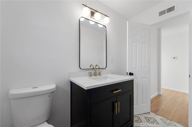 bathroom with hardwood / wood-style floors, vanity, and toilet