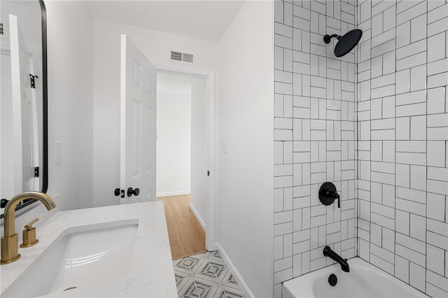 bathroom featuring hardwood / wood-style floors, vanity, and tiled shower / bath