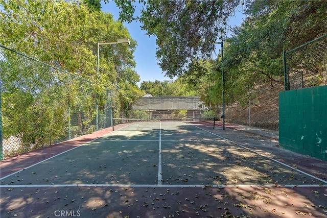 view of tennis court featuring fence