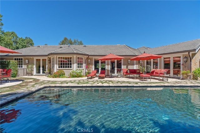 outdoor pool featuring a patio area and french doors