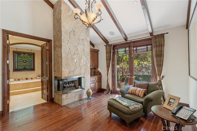 living room with beamed ceiling, a stone fireplace, french doors, wood finished floors, and high vaulted ceiling