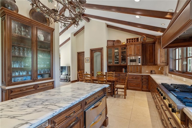 kitchen with light stone countertops, beam ceiling, stainless steel appliances, glass insert cabinets, and tasteful backsplash