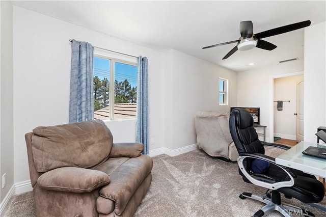 carpeted home office featuring ceiling fan