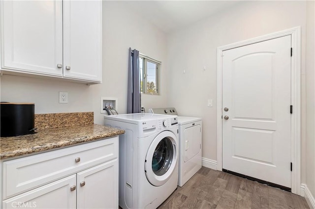 laundry room with washer and dryer, cabinets, and light hardwood / wood-style flooring