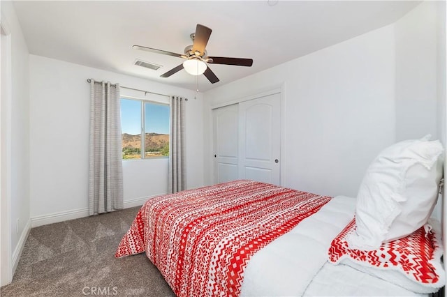 carpeted bedroom with ceiling fan and a closet