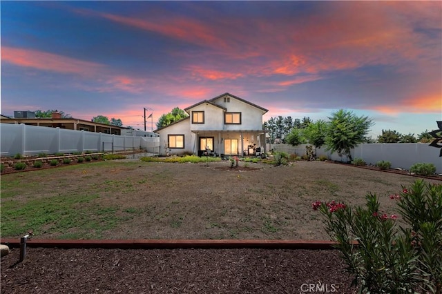 view of back house at dusk