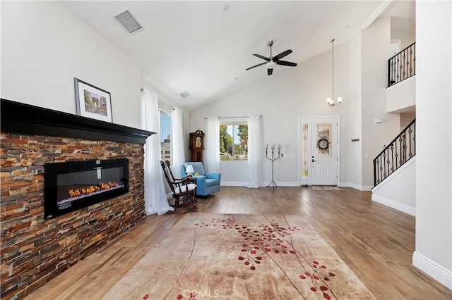 unfurnished living room featuring light hardwood / wood-style floors, a fireplace, and high vaulted ceiling