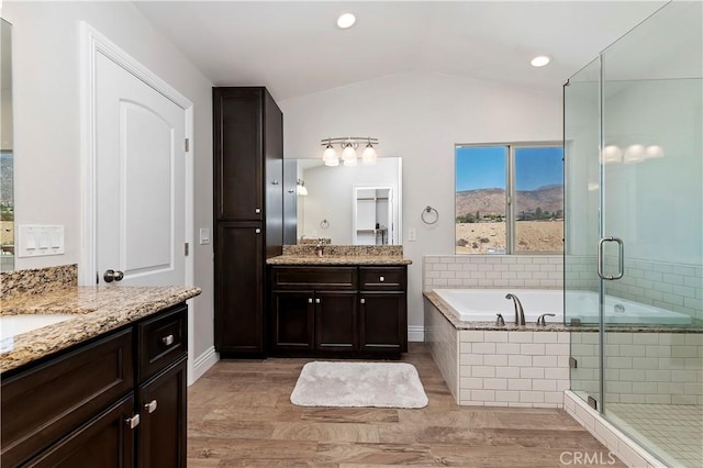 bathroom with shower with separate bathtub, vanity, hardwood / wood-style flooring, and vaulted ceiling