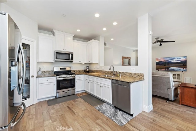 kitchen featuring sink, white cabinets, light wood-type flooring, and appliances with stainless steel finishes