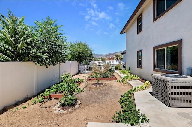 view of yard featuring a mountain view, a patio area, and central AC