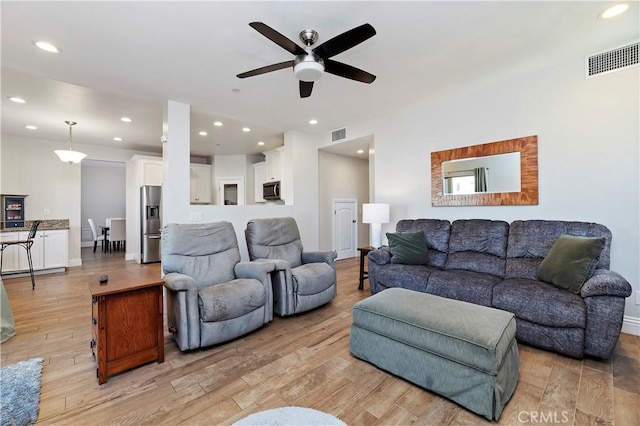 living room with light hardwood / wood-style floors and ceiling fan