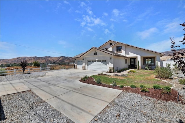 view of front of home featuring a mountain view, a garage, and a front lawn