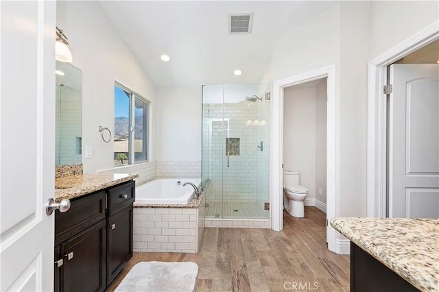 full bathroom featuring plus walk in shower, toilet, vanity, and hardwood / wood-style flooring