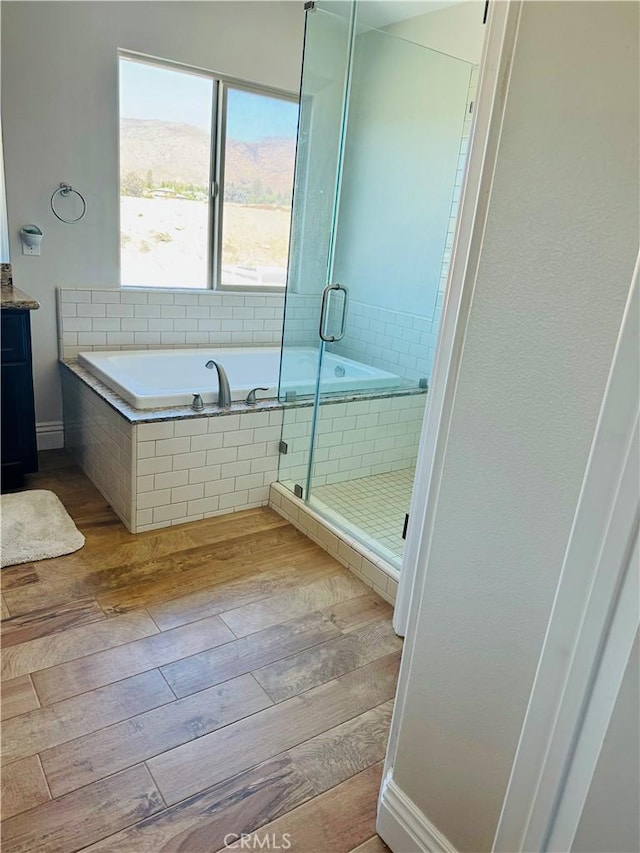 bathroom with vanity, wood-type flooring, and shower with separate bathtub