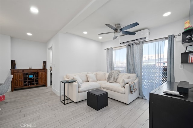 living room featuring ceiling fan, a wall mounted AC, and light hardwood / wood-style flooring