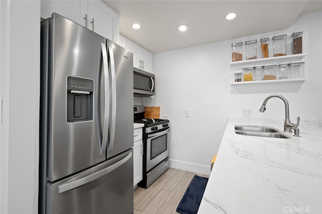 kitchen featuring white cabinets, light hardwood / wood-style floors, stainless steel appliances, and sink