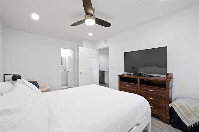 bedroom with light hardwood / wood-style flooring, ensuite bath, and ceiling fan