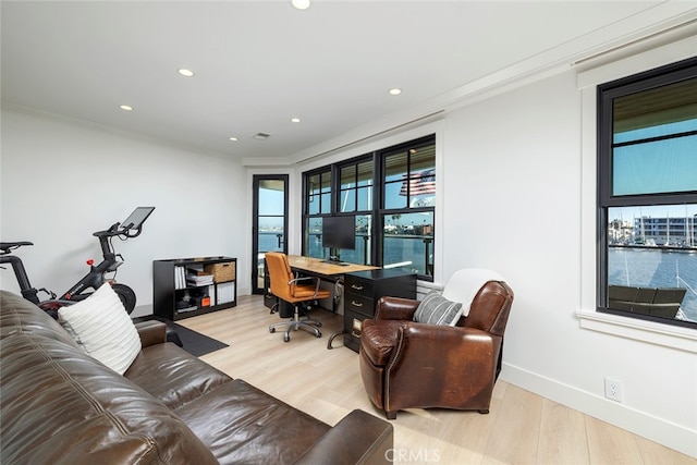 interior space with baseboards, ornamental molding, wood finished floors, and recessed lighting