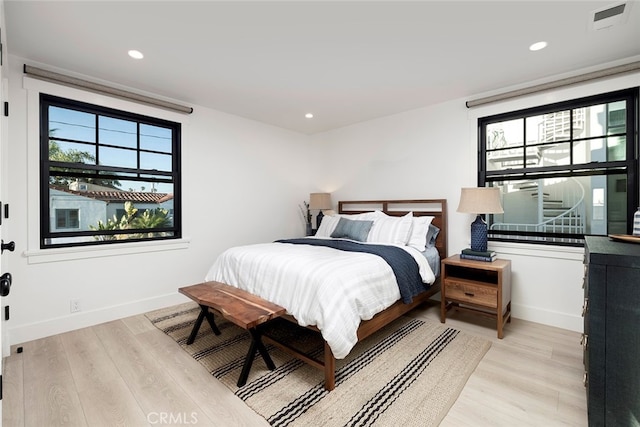 bedroom with light hardwood / wood-style flooring and multiple windows